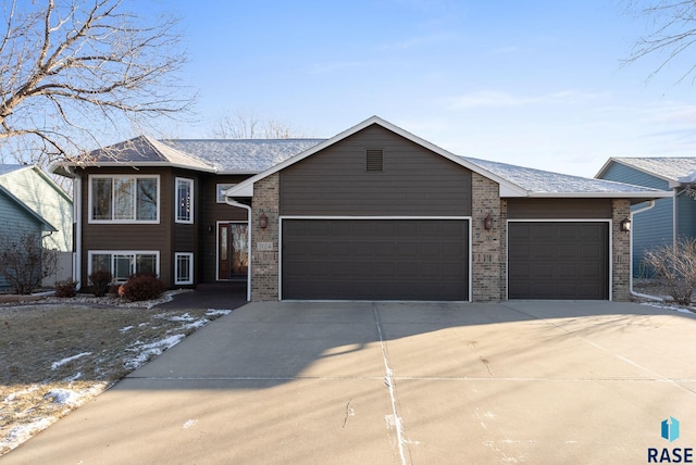 view of front of property with brick siding, driveway, and an attached garage