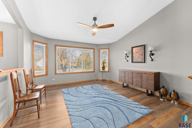 sitting room with lofted ceiling, ceiling fan, baseboards, and wood finished floors