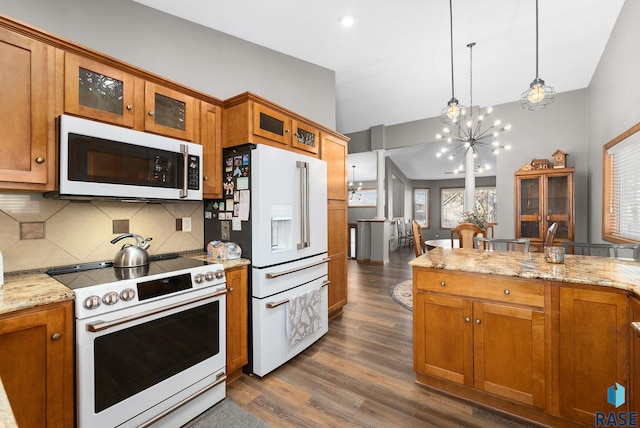 kitchen featuring a notable chandelier, white appliances, brown cabinetry, dark wood finished floors, and pendant lighting