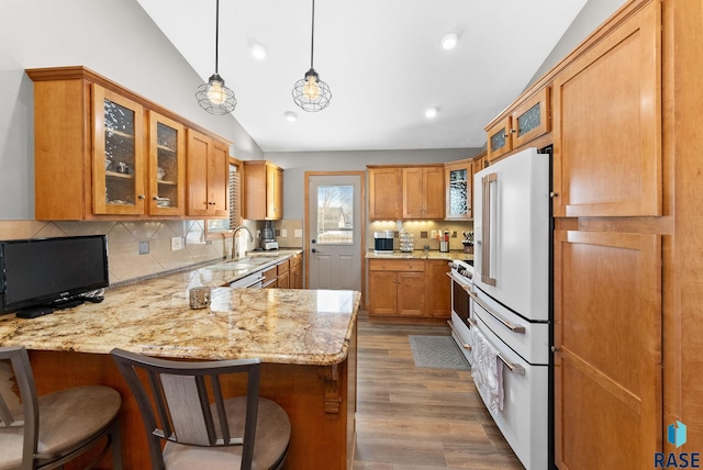 kitchen featuring vaulted ceiling, high end white fridge, a peninsula, and decorative backsplash