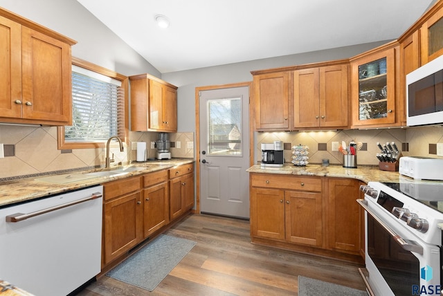 kitchen featuring vaulted ceiling, white appliances, light wood finished floors, and a healthy amount of sunlight