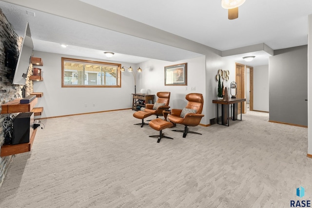 living area featuring a ceiling fan, carpet flooring, and baseboards