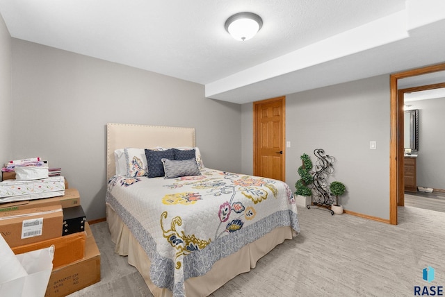 bedroom with light colored carpet and baseboards