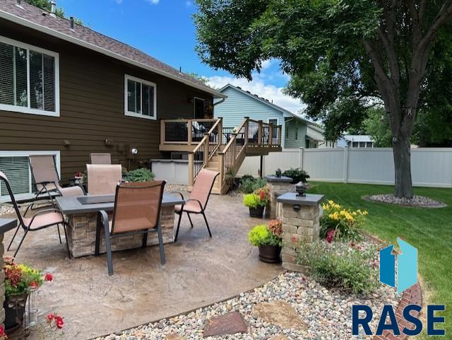 view of patio featuring stairway, fence, a deck, and outdoor dining space