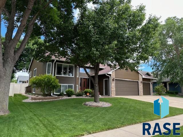 view of front of home with an attached garage, driveway, and a front yard