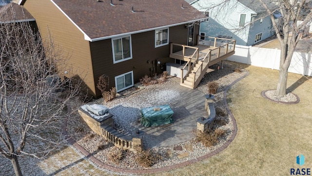 rear view of property with stairway, roof with shingles, fence, and a deck