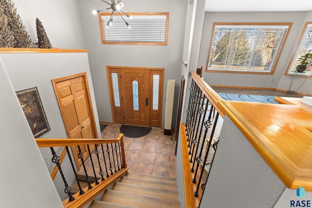 entrance foyer featuring stairway and a notable chandelier