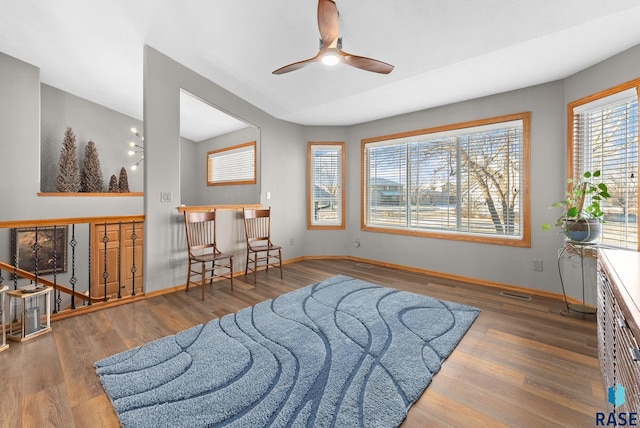 interior space featuring a healthy amount of sunlight, visible vents, baseboards, and wood finished floors