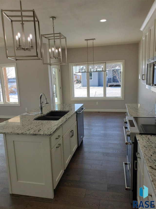 kitchen featuring dark wood-style floors, appliances with stainless steel finishes, white cabinets, and a sink