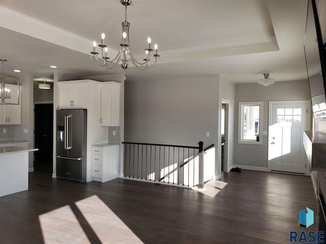 kitchen featuring a tray ceiling, dark wood finished floors, an inviting chandelier, white cabinetry, and high end refrigerator