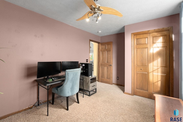 carpeted home office with ceiling fan, a textured ceiling, and baseboards