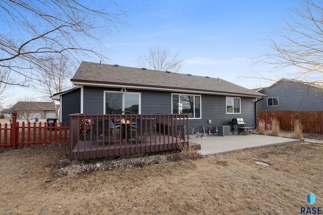 back of house with a fenced backyard, a patio, central AC, and roof with shingles