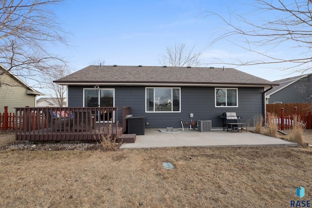 rear view of house with a patio, roof with shingles, fence, a yard, and central air condition unit