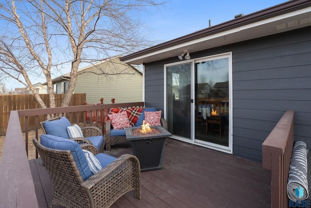 wooden terrace with an outdoor fire pit and fence