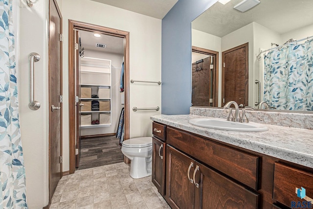 bathroom with visible vents, toilet, and vanity