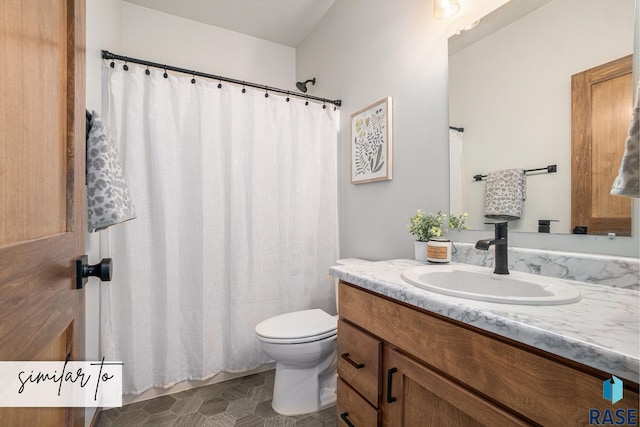 bathroom featuring toilet, curtained shower, and vanity