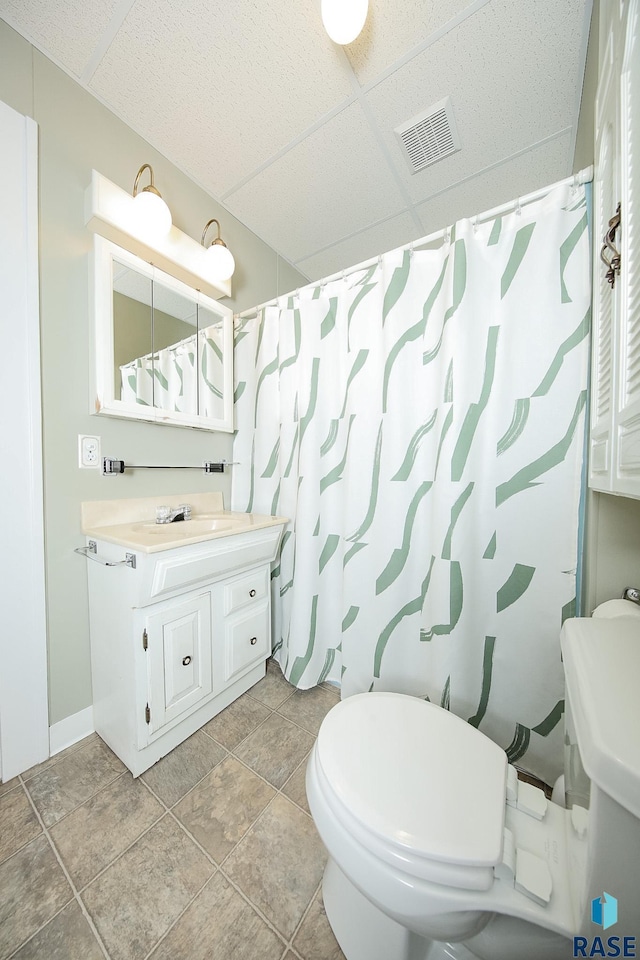 full bathroom featuring toilet, visible vents, a paneled ceiling, and vanity