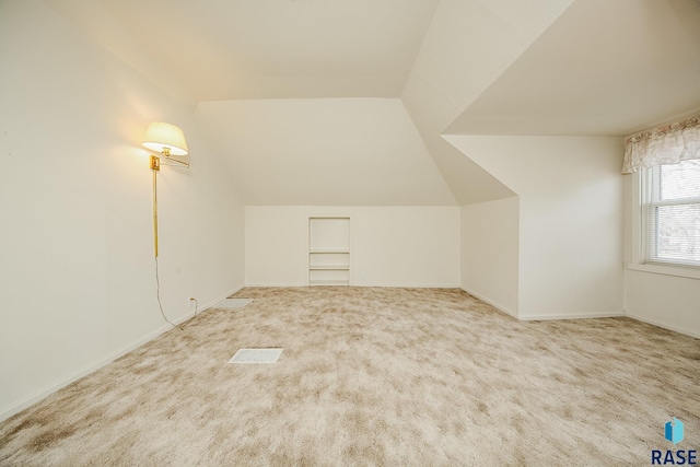 bonus room featuring vaulted ceiling and carpet flooring