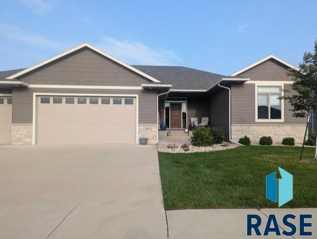 ranch-style home featuring driveway, a front lawn, an attached garage, and stone siding