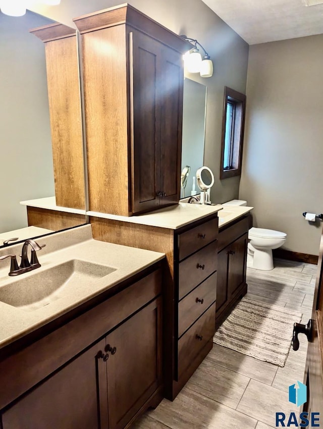 bathroom featuring wood finished floors, vanity, and toilet