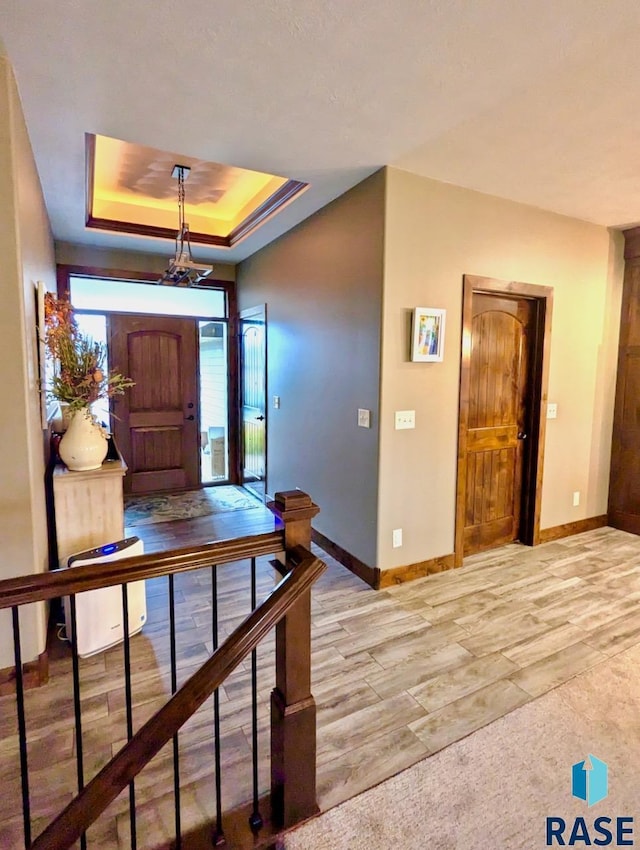 entrance foyer with baseboards and a tray ceiling