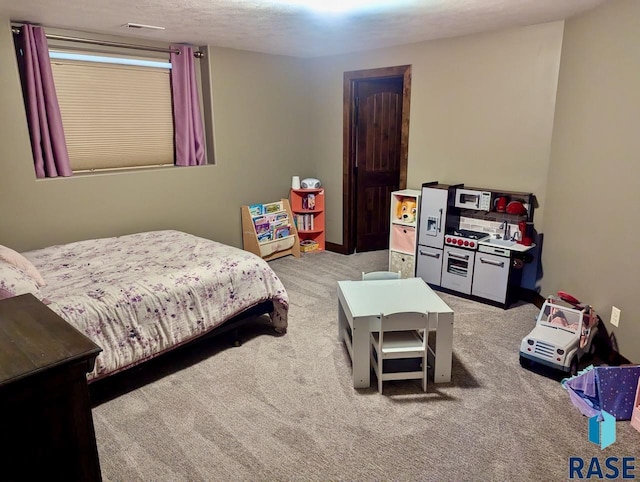 bedroom featuring carpet and a textured ceiling