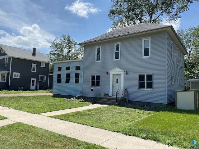 colonial house featuring a front lawn