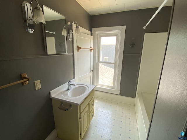 full bathroom featuring vanity, baseboards, washtub / shower combination, and tile patterned floors