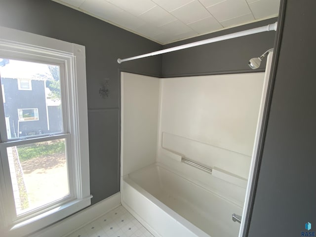 bathroom with baseboards, bathtub / shower combination, and tile patterned floors