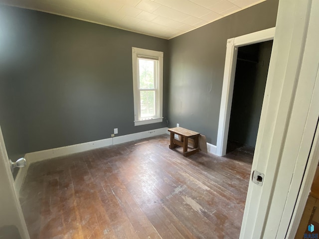 bedroom with wood-type flooring and baseboards