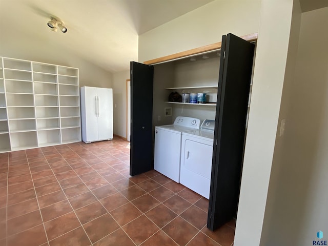 clothes washing area with laundry area, dark tile patterned floors, and washing machine and dryer