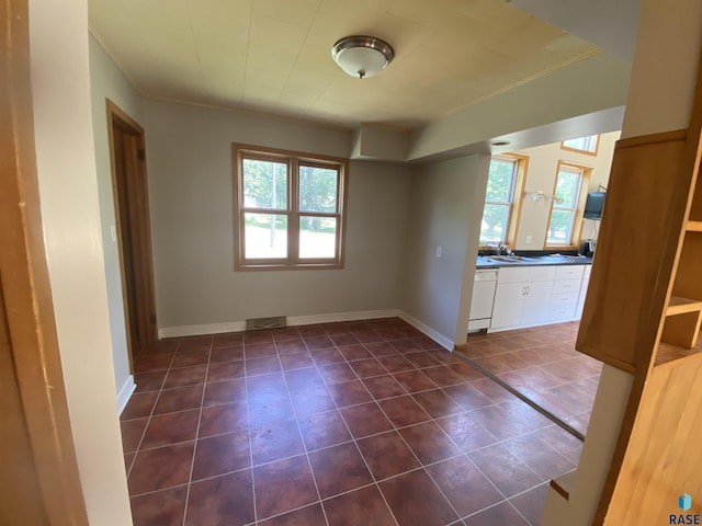 interior space with visible vents, ornamental molding, a sink, dark tile patterned floors, and baseboards