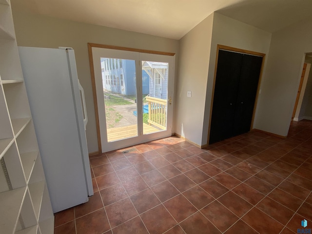 doorway featuring dark tile patterned floors, visible vents, and baseboards