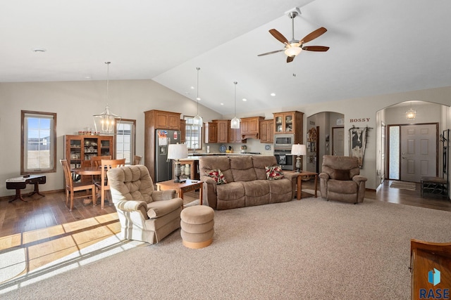 living area with high vaulted ceiling, a ceiling fan, arched walkways, and a wealth of natural light