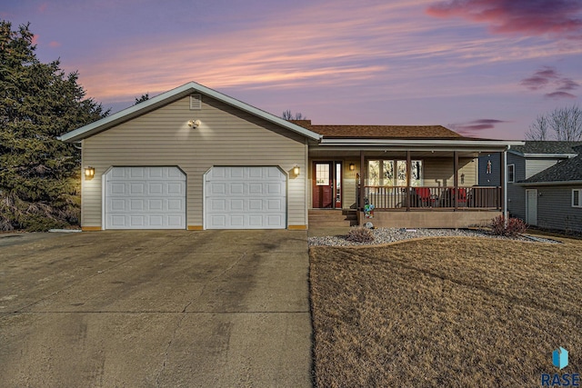 ranch-style home featuring concrete driveway, a porch, a front lawn, and an attached garage