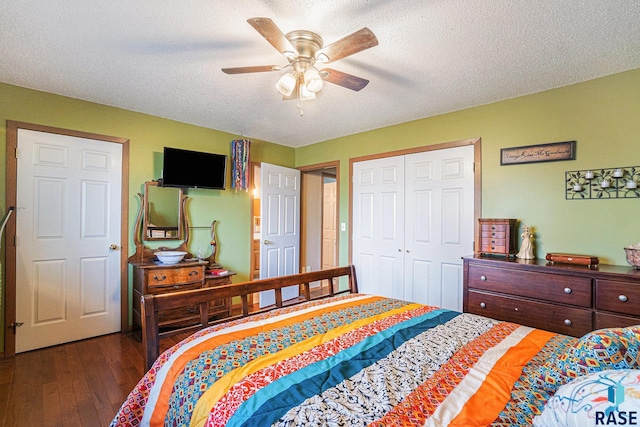 bedroom with a textured ceiling, ceiling fan, dark wood-style flooring, and a closet