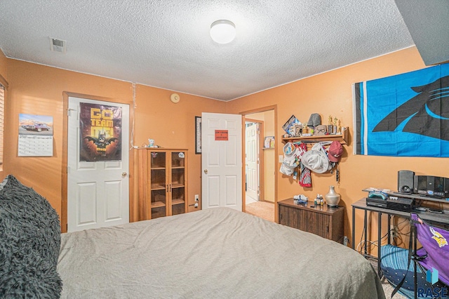 bedroom with a textured ceiling and visible vents