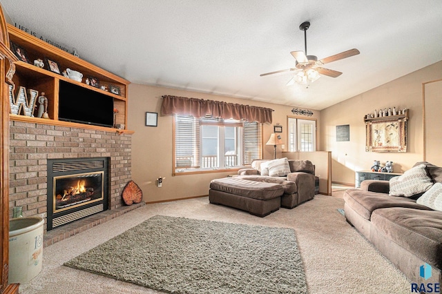 living area with a textured ceiling, carpet flooring, a ceiling fan, vaulted ceiling, and a brick fireplace