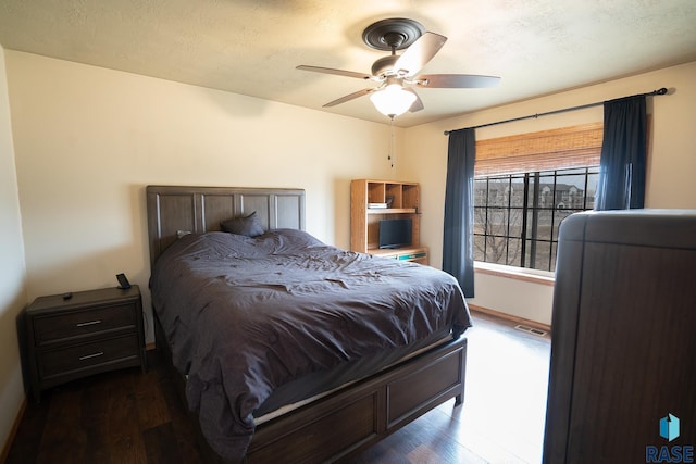 bedroom featuring ceiling fan, a textured ceiling, and wood finished floors