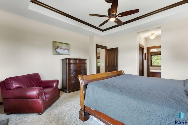 bedroom with ensuite bathroom, carpet floors, a raised ceiling, and a ceiling fan