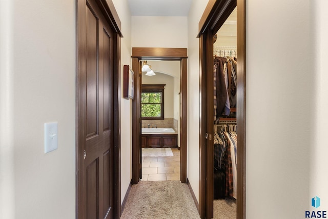 corridor featuring light carpet and light tile patterned flooring