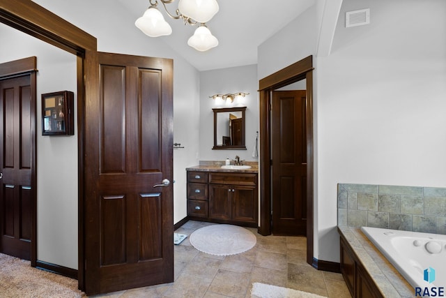 bathroom with visible vents, a garden tub, vanity, and baseboards