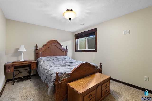 bedroom with light colored carpet and baseboards