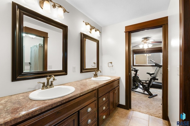 bathroom featuring ceiling fan, double vanity, a sink, and tile patterned floors