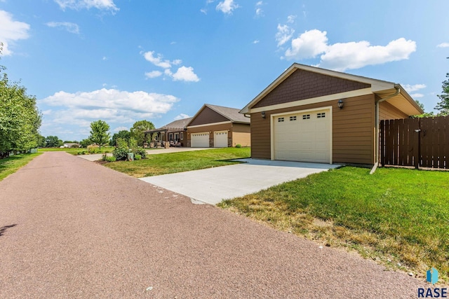 view of front facade with a garage, a front yard, and fence