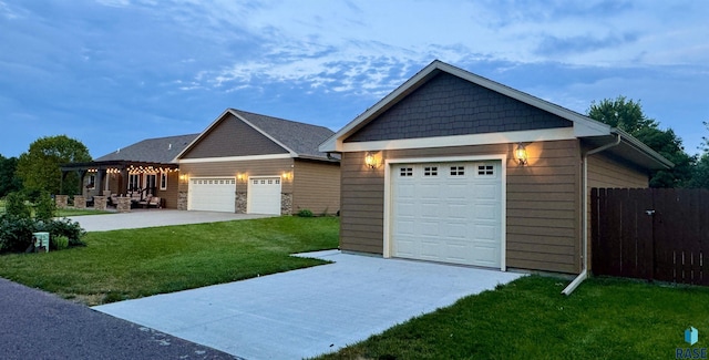 view of front of house featuring an attached garage, fence, concrete driveway, a pergola, and a front yard