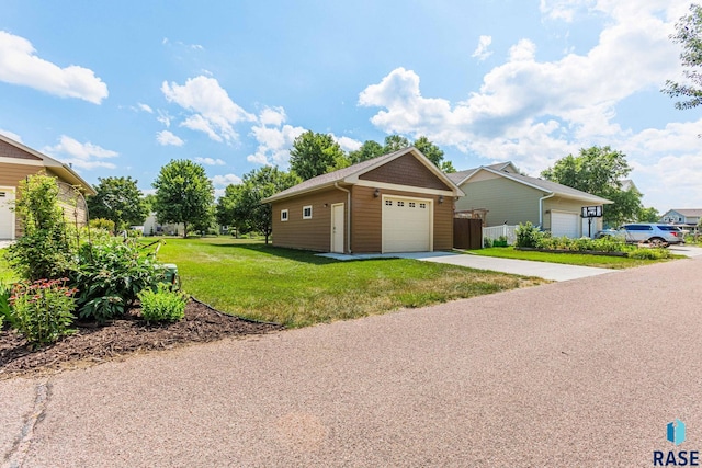 view of front of home with a garage, a front yard, an outdoor structure, and fence