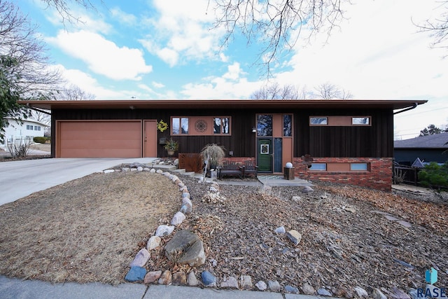 view of front facade featuring a garage, driveway, and brick siding