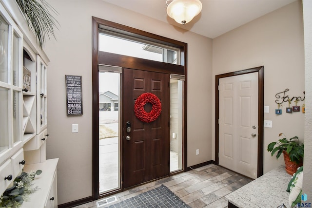 entrance foyer with light wood-type flooring, visible vents, and baseboards