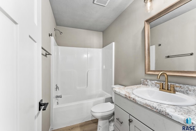 full bathroom featuring shower / bath combination, visible vents, toilet, wood finished floors, and vanity